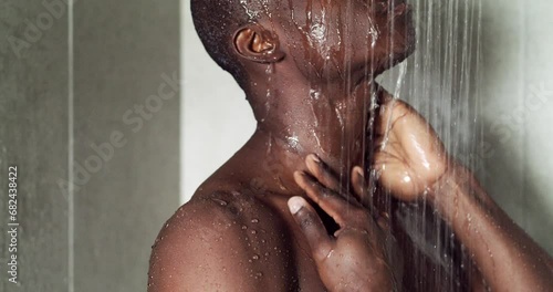 Man, shower and cleaning body for hygiene, water and healthy skin or naked, morning routine and liquid. Black male person, fresh and bare at home, bathroom and cosmetics or dermatology, wash and zoom photo