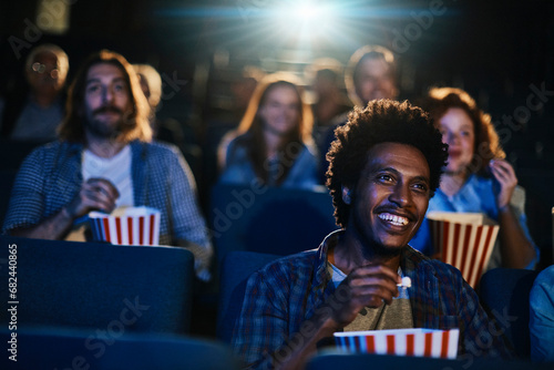 Smiling young man watching a movie in theater photo