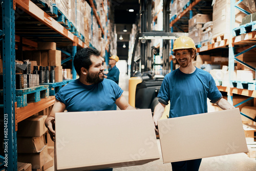 Diverse warehouse workers working and carrying boxes in a warehouse photo