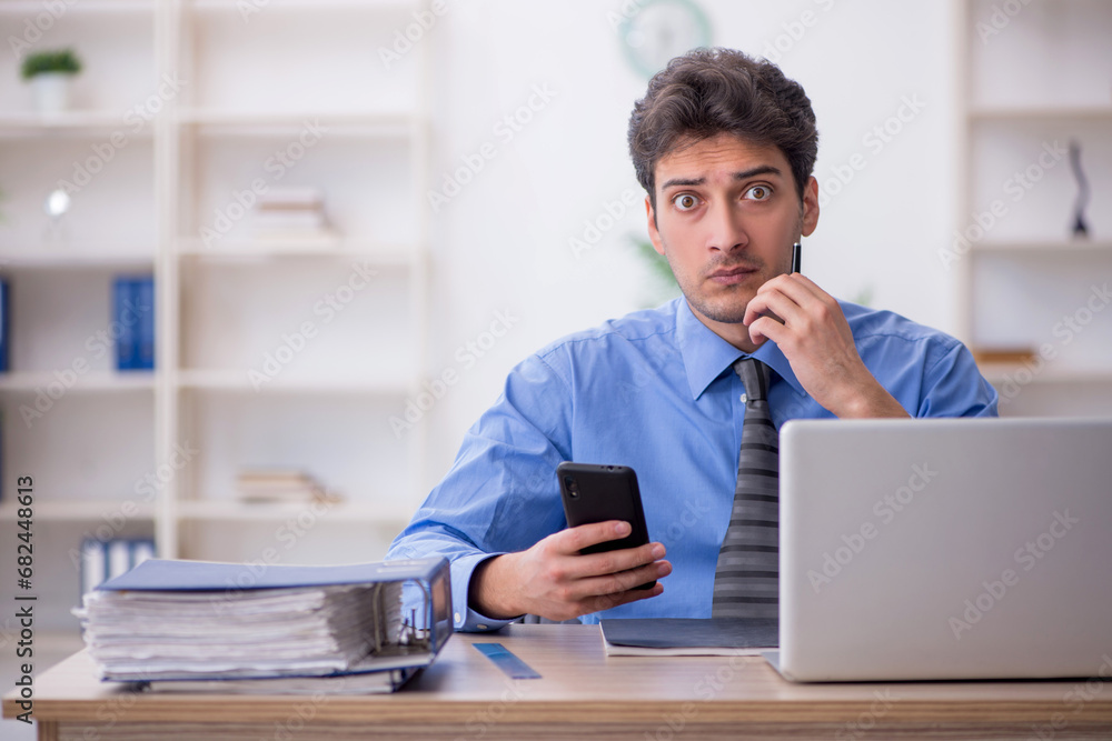 Young male employee working in the office Young male employee working in the office