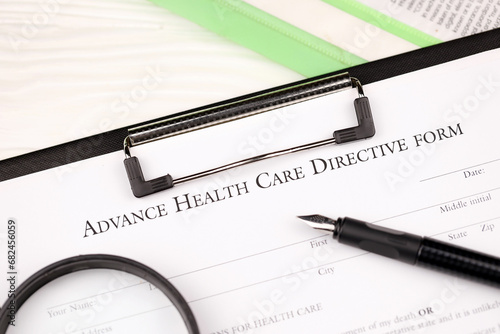 Advance health care directive blank form on A4 tablet lies on office table with pen and magnifying glass close up photo