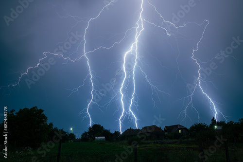 Branched thunderbolts of lighting are hitting the earth at night