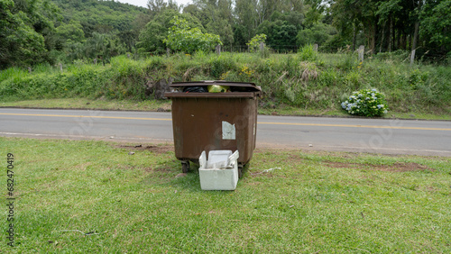 Caçamba e lixo geral e de isopor em Gramado sobre a grama photo