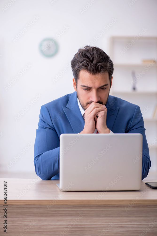 Young male employee working in the office Young male employee working in the office