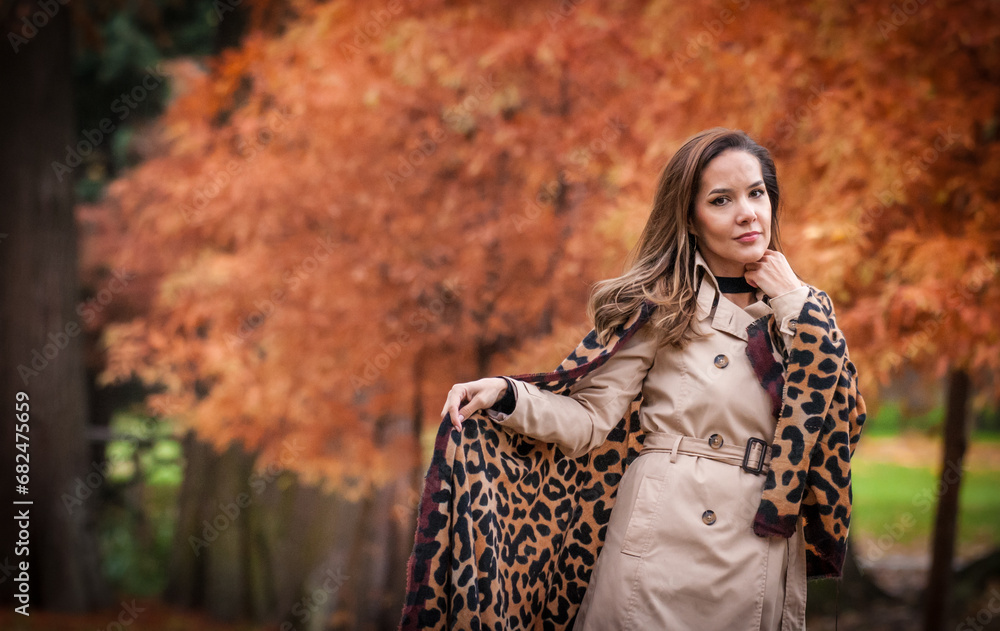 young girl in coat in forest. Fashion woman in coat in park. Slim young fashion model wearing white coat outdoor. Beautiful woman in leopard coat in the autumn park