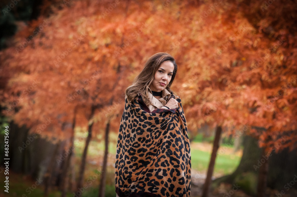 young girl in coat in forest. Fashion woman in coat in park. Slim young fashion model wearing white coat outdoor. Beautiful woman in leopard coat in the autumn park