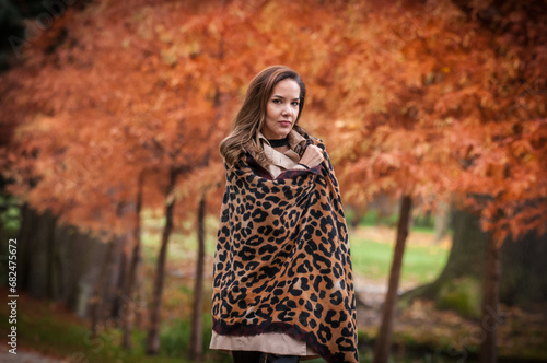 Obraz na płótnie young girl in coat in forest. Fashion woman in coat in park. Slim young fashion model wearing white coat outdoor. Beautiful woman in leopard coat in the autumn park w salonie