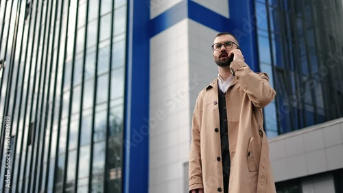 Wallpaper Mural Modern business man in beige trench talking smartphone office building street downtown skyscraper Torontodigital.ca