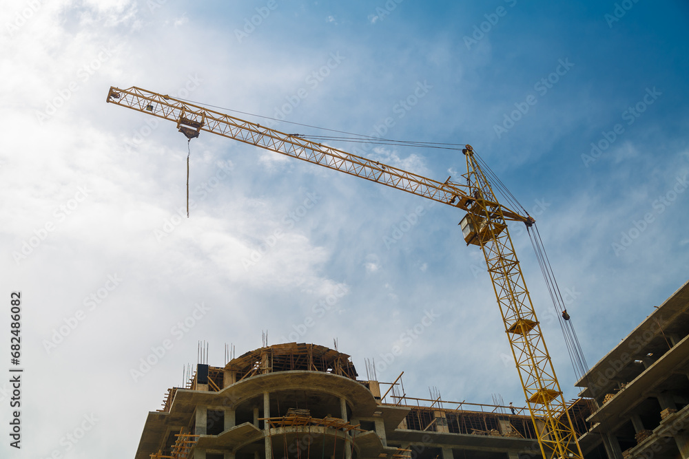 Construction of a multi-storey building in a new area by a tower crane. Construction of a multi-storey building in a new area by a tower crane.