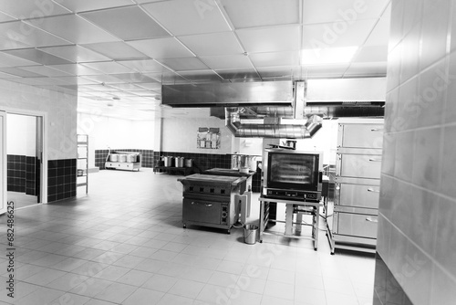 Industrial kitchen in a school restaurant with professional equipment and pans photo