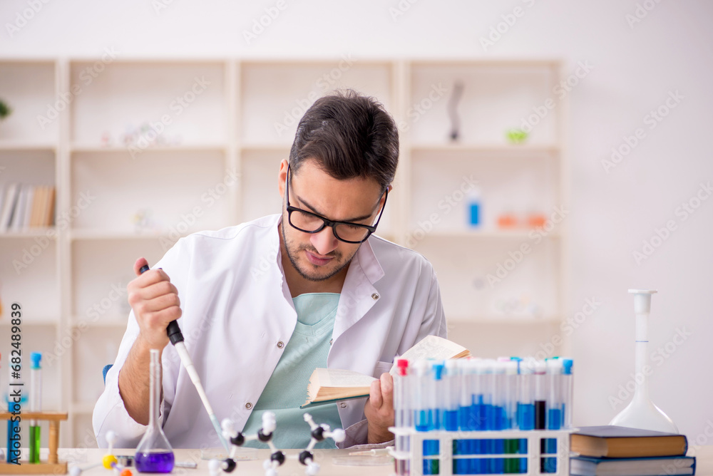 Young male chemist sitting at the lab Young male chemist sitting at the lab