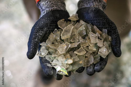 An operator shows a handful of white glass to recycle