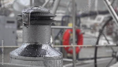 Stainless steel winch on a sailing yacht gets wet in the pouring rain photo