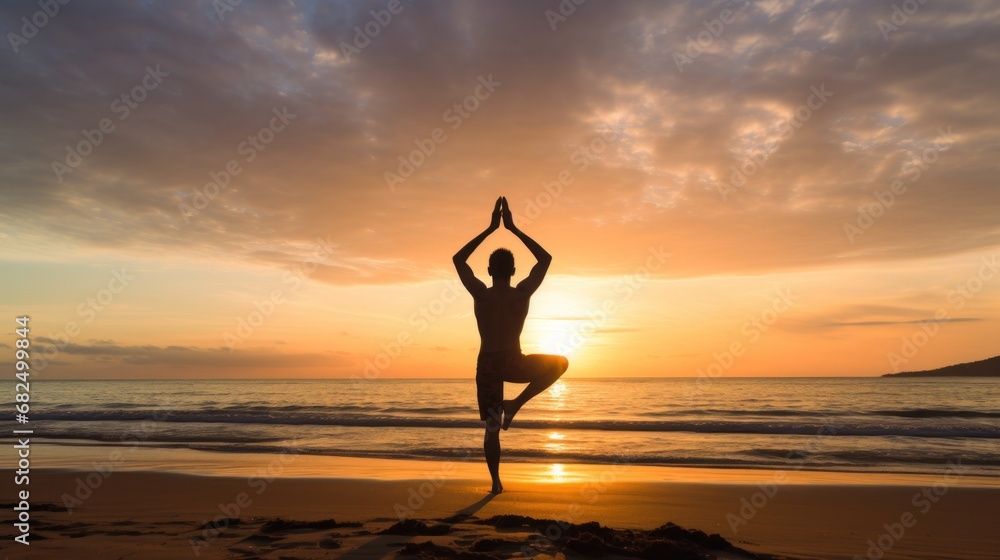 A man doing yoga on a beach, with the ocean and sunrise in the background