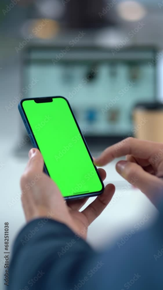 Close-up Of Mobile Phone With Green Mock-up Screen In Men's Hands On Desktop Background. Man Using Smartphone, Browsing Internet, Social Networks, Financial Reports Close-up Of Mobile Phone With Green Mock-up Screen In Men's Hands On Desktop Background. Man Using Smartphone, Browsing Internet, Social Networks, Financial Reports