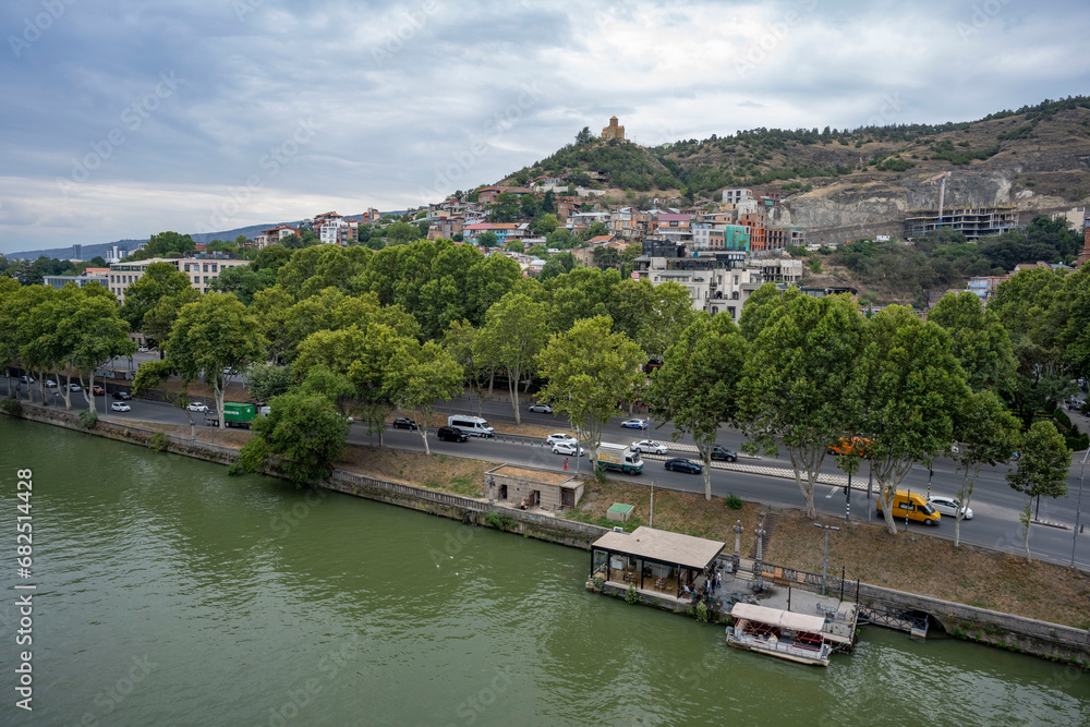 The Kura River running through Tbilisi, bridges and boats cruising on the river. 