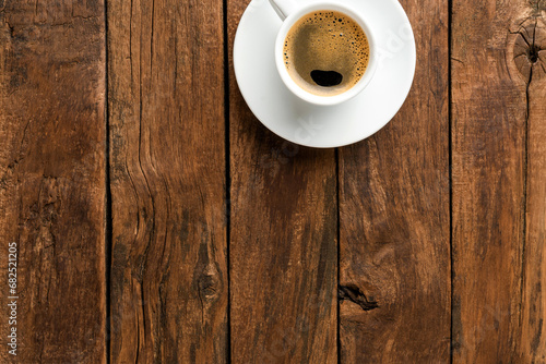 Black coffee cup on retro wooden background with copyspace. Top view