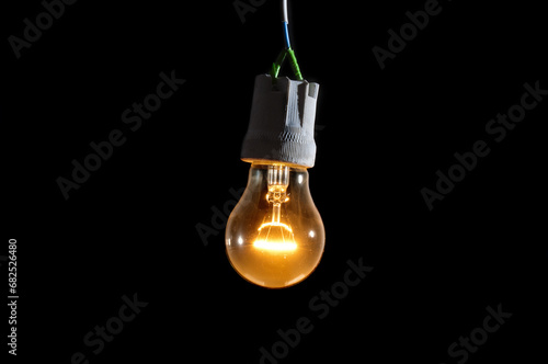 Glowing vintage light bulb close up on black background