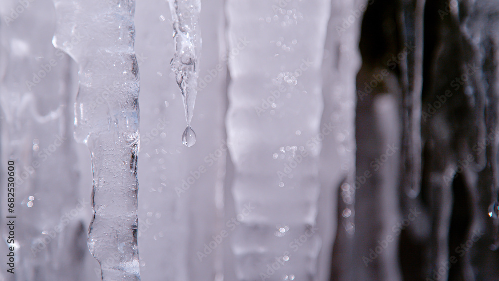 MACRO, DOF: Thick melting icicles with a dripping tiny crystal clear water drop MACRO, DOF: Thick melting icicles with a dripping tiny crystal clear water drop