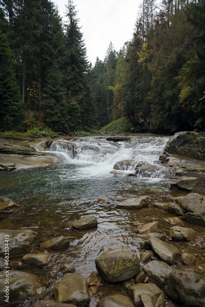 A bright blue river flowing through forest in a hidden park along the scenic drive in Hoverla mountains area in Ukraine A bright blue river flowing through forest in a hidden park along the scenic drive in Hoverla mountains area in Ukraine