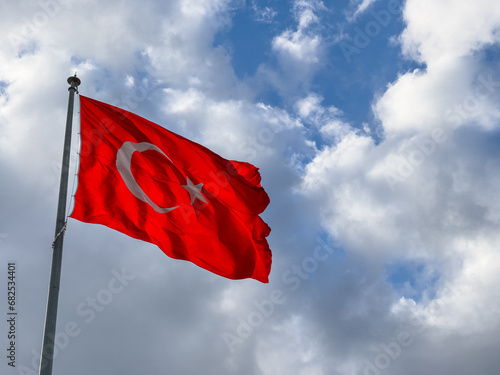  Turkish flag waving in blue cloudly sky. 19 mayis, 23 nisan, 15 temmuz, 30 agustos, 29 ekim, 10 kasim. Turkish nation. 19 may, 23 april, 15 july, 30 august, 29 october.