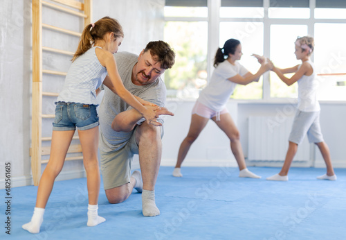 Parents and children during training and self-defense workout. Training moment of neutralizing enemy, transformation of attack into defense. photo