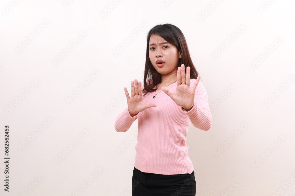Young asian girl standing while making stop gesture. Rejection concept. Isolated on white background Young asian girl standing while making stop gesture. Rejection concept. Isolated on white background