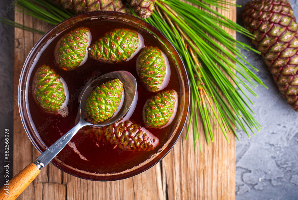 Young pine cones jam in glass bowl on wooden board. Delicious jam with the little pine cones. Young pine cones jam in glass bowl on wooden board. Delicious jam with the little pine cones.