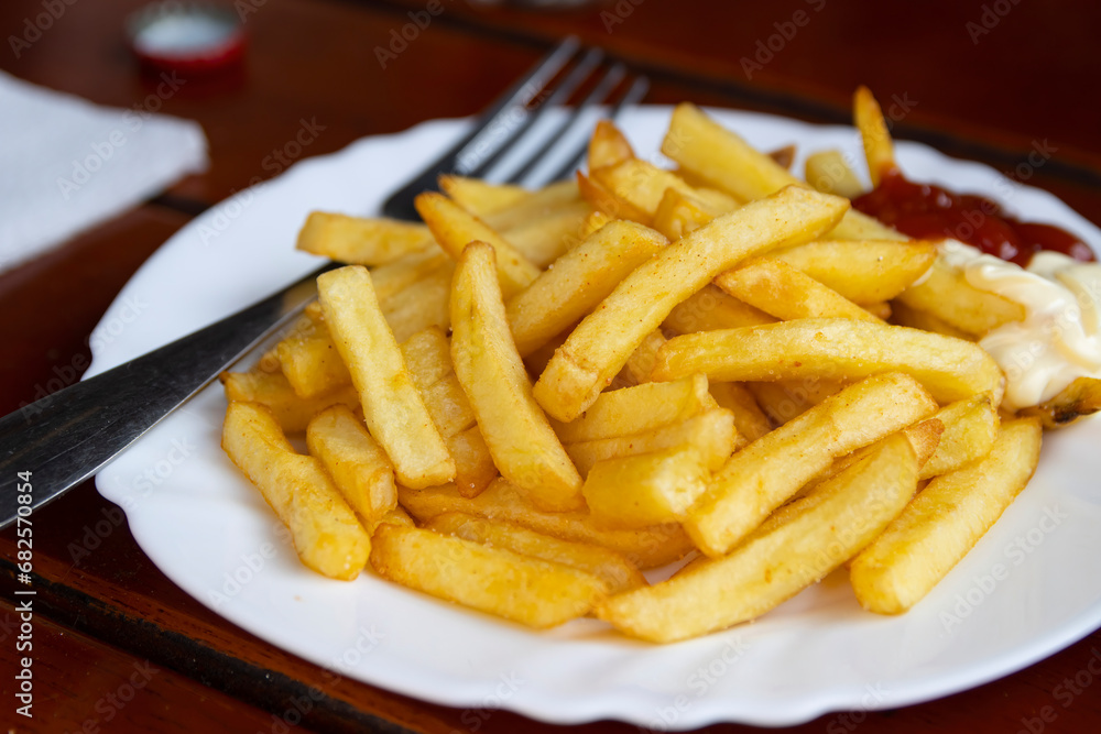 Pommes frites - also called chips or French fries - served with ketchup and mayonnaise condiments on the side. Pommes frites - also called chips or French fries - served with ketchup and mayonnaise condiments on the side.