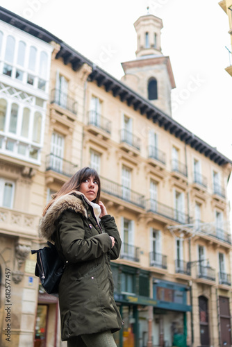 Caucasian tourist in green coat, Pamplona, cloudy autumn day, iconic backdrop.