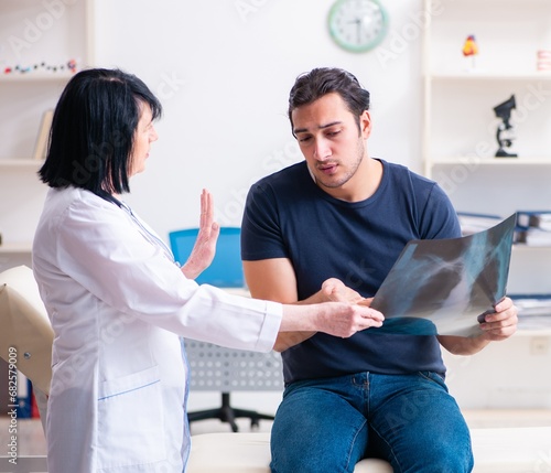 Young male patient visiting aged female doctor