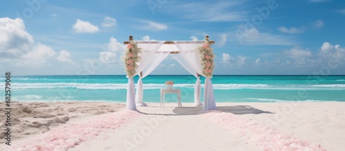 Fototapeta Naklejka Na Ścianę i Meble -  As the sun radiated its warm rays down on the white sandy beach, the picturesque landscape of the tropical paradise set the stage for a breathtaking summer wedding ceremony. With the gentle sound of