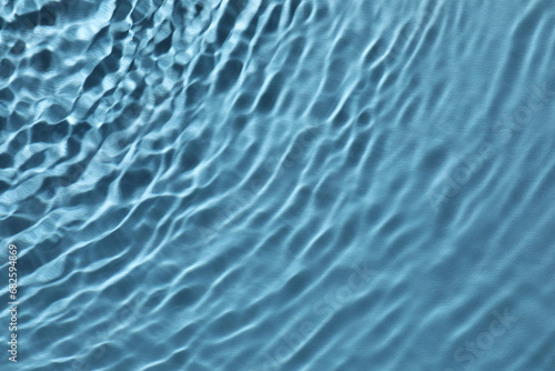 Rippled surface of clear water on light blue background  top view