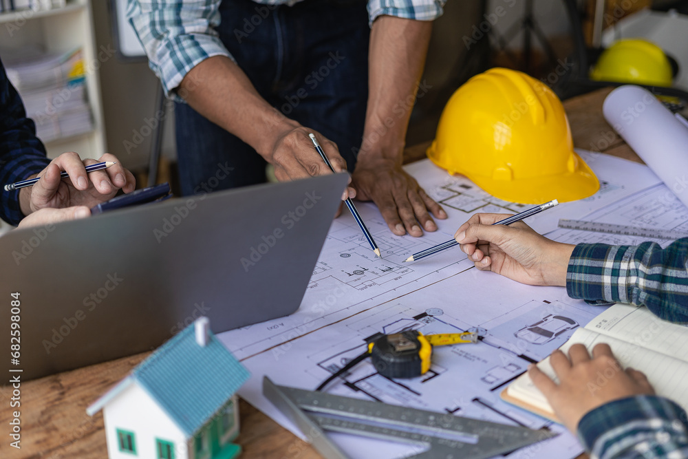 Concept architect, engineer, team holding pen, pointing architect, equipment on table with blueprints, ready to discuss home design in office. Concept architect, engineer, team holding pen, pointing architect, equipment on table with blueprints, ready to discuss home design in office.
