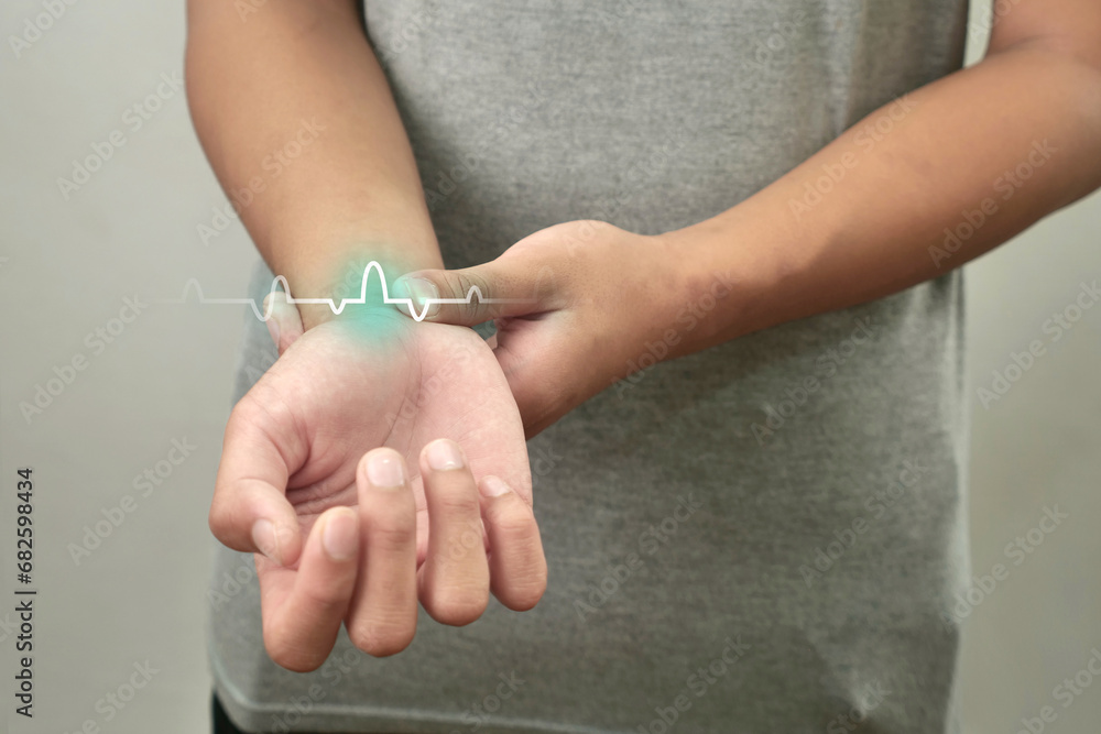 Anonymous person touching his wrist, measuring heart pulse Anonymous person touching his wrist, measuring heart pulse