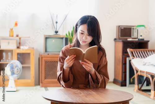 古風な雰囲気の家で読書をする若い女性