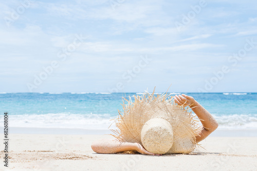 Woman lies on the white sand on the beach