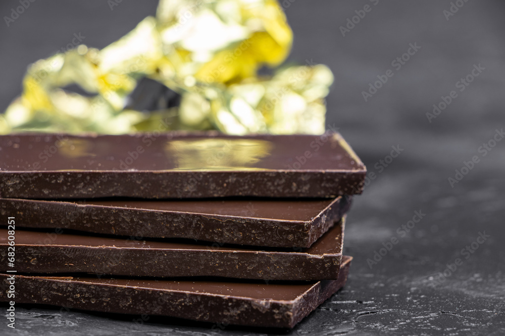 Dark chocolate on a dark background. Bar of dark chocolate. Chocolate pieces Dark chocolate on a dark background. Bar of dark chocolate. Chocolate pieces