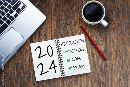 2024 Happy New Year Resolution Goal List and Plans Setting - Business office desk with notebook written about plan listing of new year goals and resolutions setting. Change and bliss concept.