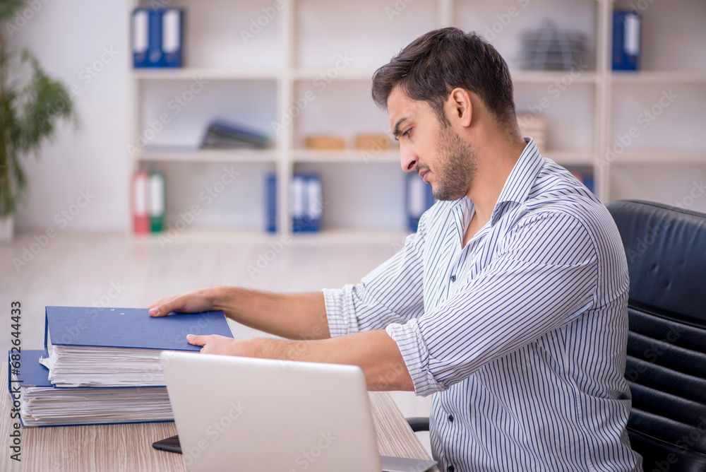 Young male employee working in the office Young male employee working in the office