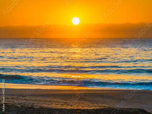 Fototapeta Naklejka Na Ścianę i Meble -  Pretty blue sunrise at the beach with calm seas
