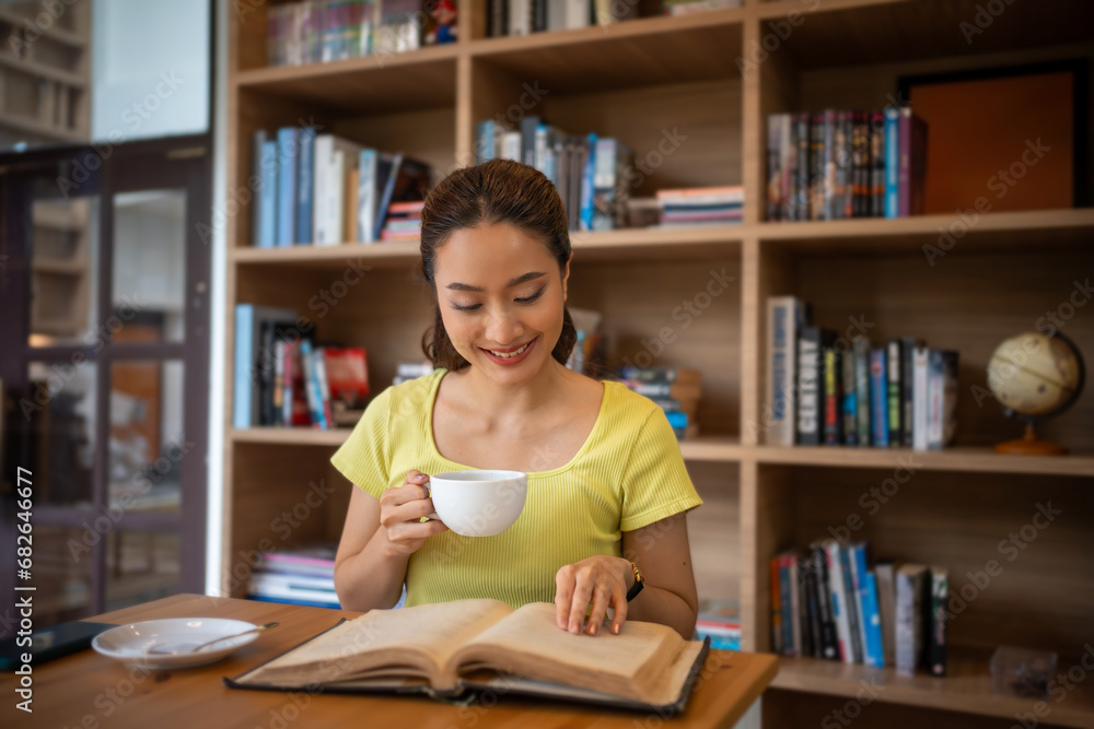 Young woman reading book and drink hot coffee in library at home, smiling, laughing, enjoying bookworms hobby, home leisure time Young woman reading book and drink hot coffee in library at home, smiling, laughing, enjoying bookworms hobby, home leisure time
