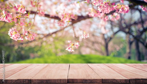 Empty wood table top and blurred sakura flower tree in garden background with vintage filter - can used for display or montage your products.