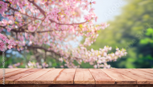 Empty wood table top and blurred sakura flower tree in garden background with vintage filter - can used for display or montage your products.