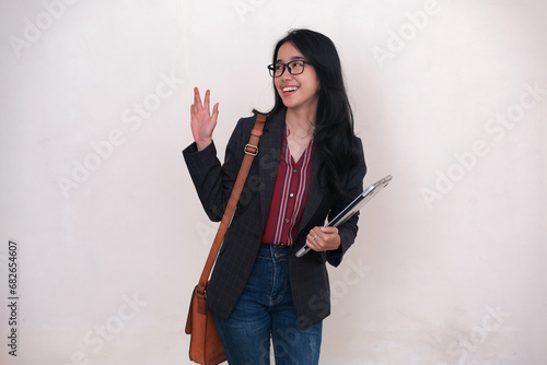 Asian business woman carrying her bag and computer leaving the office photo