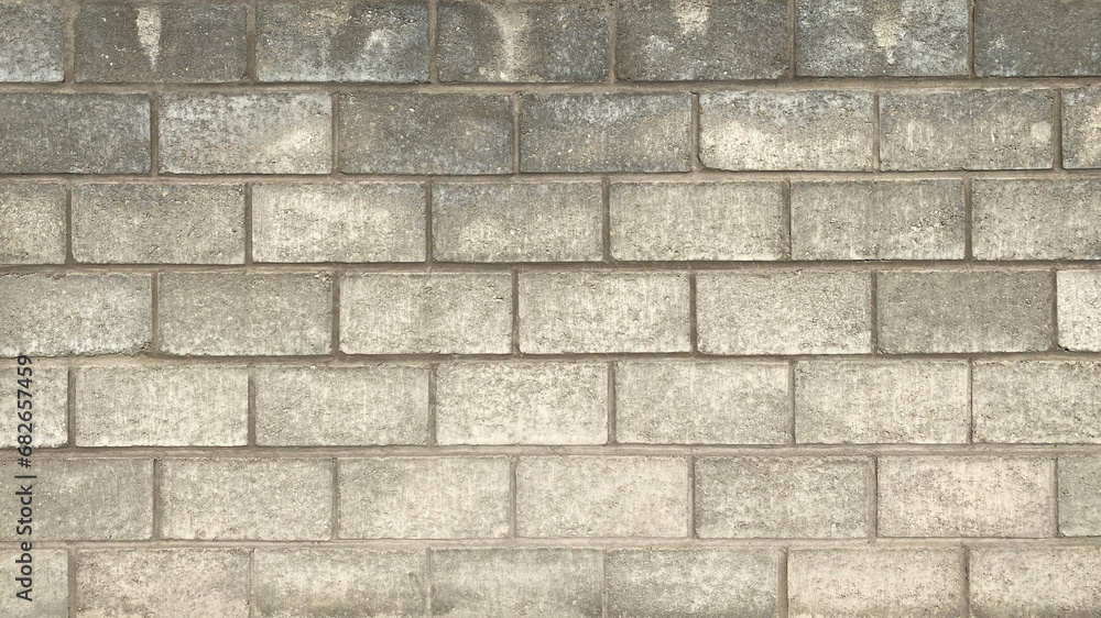 Fototapeta premium The wall is made of smooth gray large textured brick. Beautiful brickwork background.