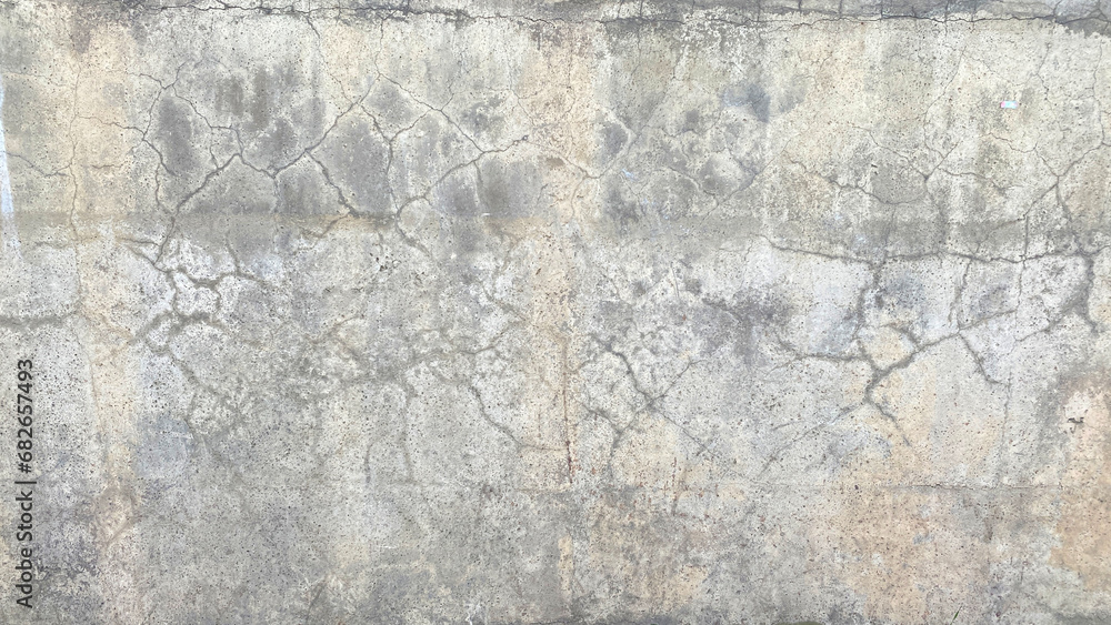 An old dirty battered concrete wall with cracks. The dilapidated wall of the building, tarnished by time.