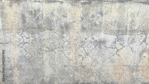 An old dirty battered concrete wall with cracks. The dilapidated wall of the building, tarnished by time.