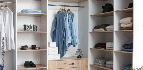 Wardrobe with clean clothes in dressing room photo