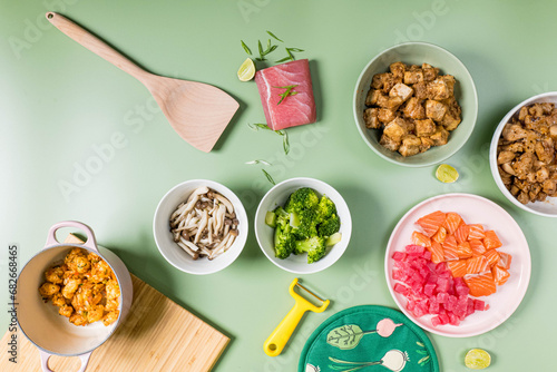 Top view of Healthy food concept.Ingredient sliced fish, mushroom, tofu, chicken fried and broccoli on a green pastel background. with text pace 